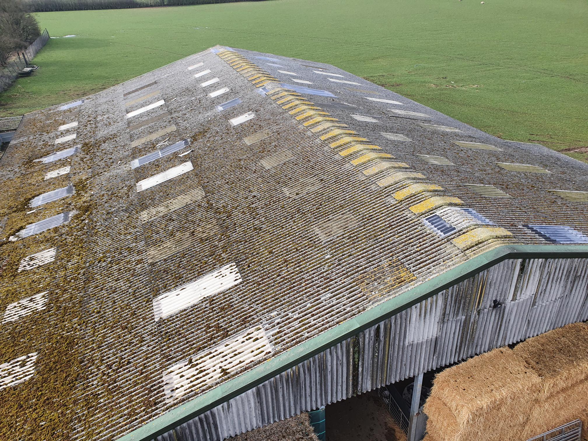 Asbestos roof before removal — deteriorated corrugated asbestos sheeting
